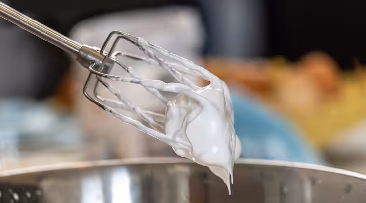 Thick white cream on the end of steel beaters.