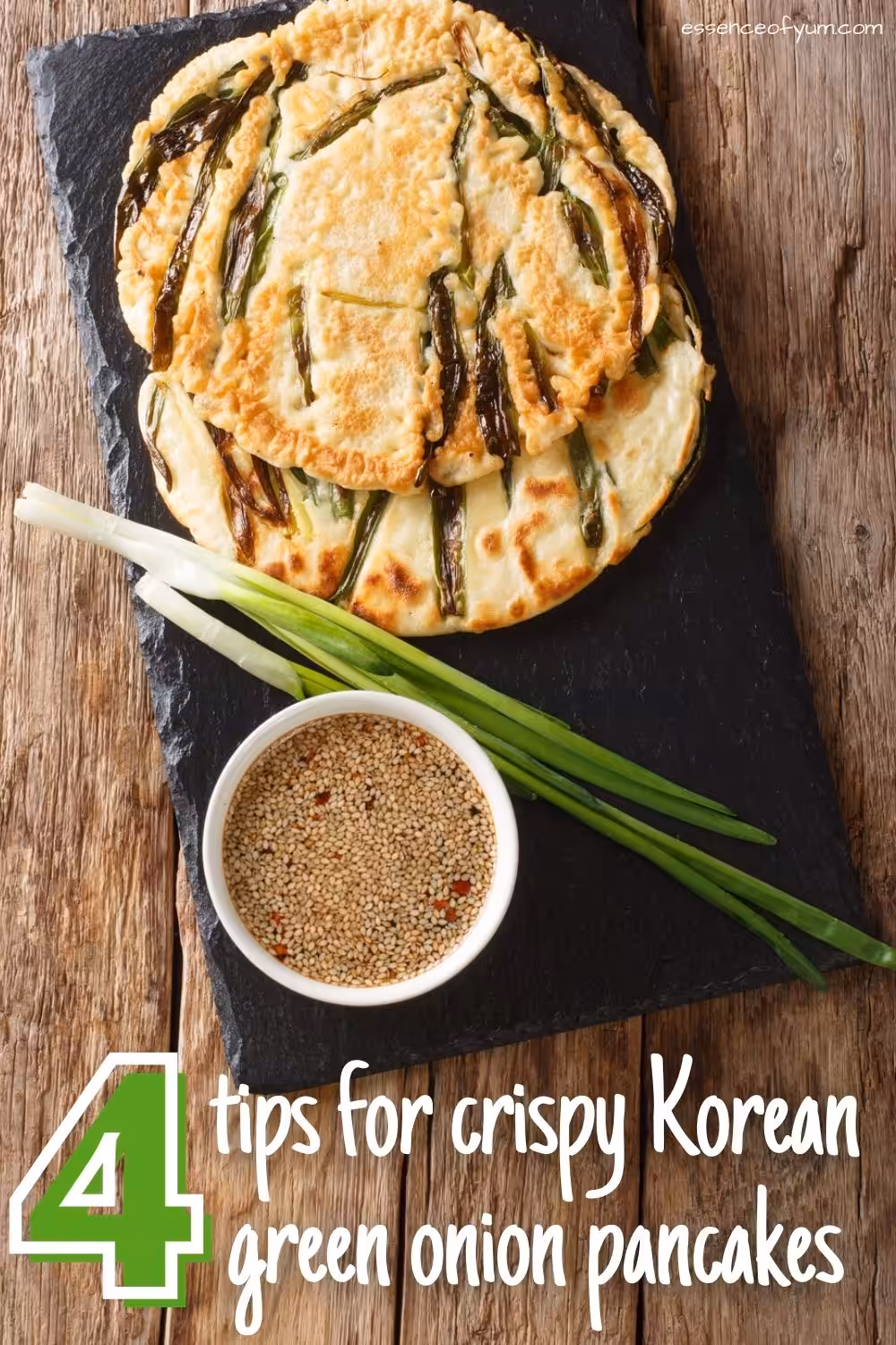 Two golden brown scallion pancakes on a stone plate with some scallions and a bowl of sesame seed dipping sauce plus the text 4 tips for crispy Korean green onion pancakes.