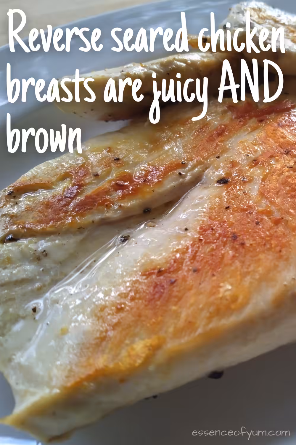 Closeup of a golden brown reverse-seared chicken breast glistening with juices with the text reverse seared chicken breasts are juicy AND brown.