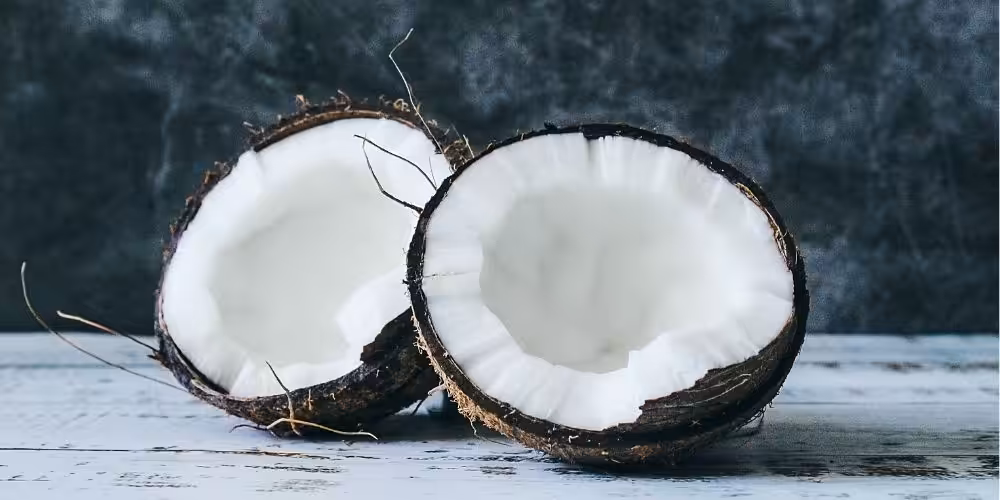Closeup of a coconut cut in half exposing it's white flesh.