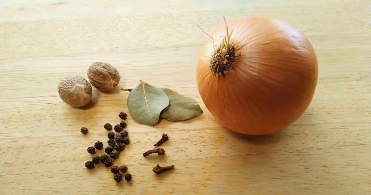 Flavourings for a bechamel sauce - nutmeg, black peppercorns, cloves, bay leaves and an onion.